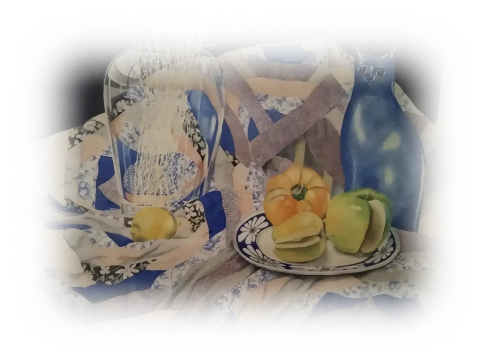 A quilt with concentric geometric patterns, is spread out organically and unevenly. Upon it are a blue, ceramic cat, a plate of fruit and a glass vase containing delicate white plants.